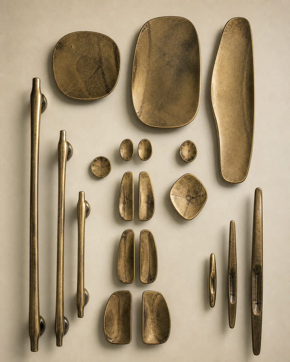 Collection of hand-cast bronze handles and knobs from the Novant workshop, laid out flat