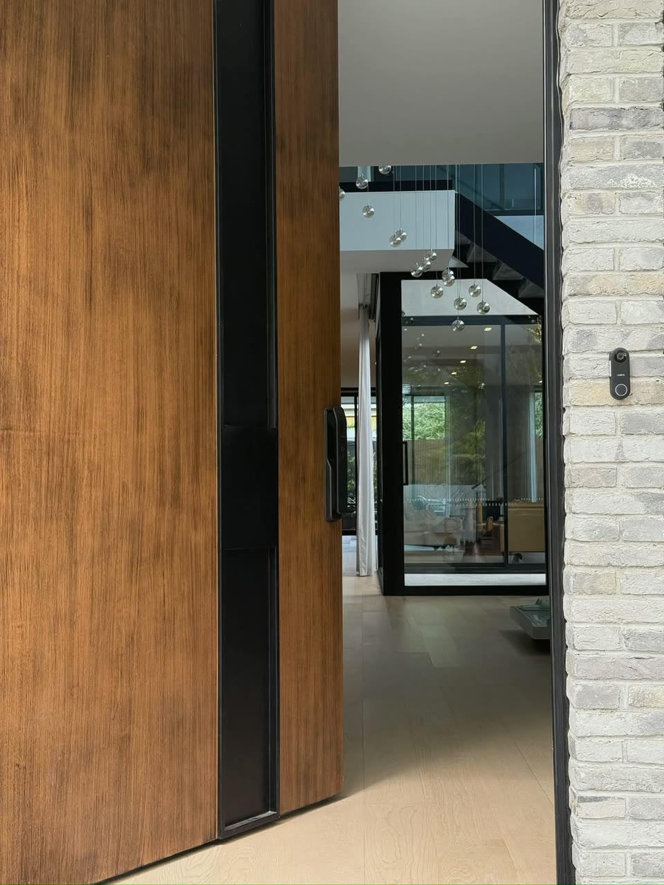 Woodgrain pivot entry door opening to a light-filled Melbourne interior