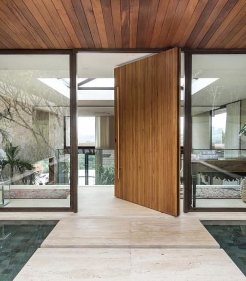 Custom pivot door in American oak with brass hardware
